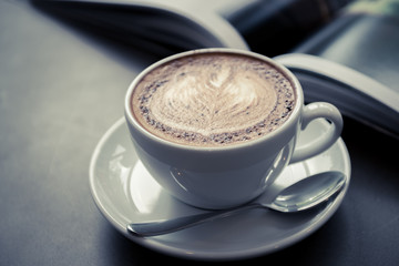 cup cappuccino coffee with a book