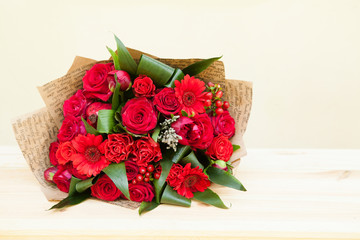 Red bouquet of roses, gerberas, peonies, pomegranates with copyspace. Love and passion symbol. Anniversary gift. Birthday gift for girl.