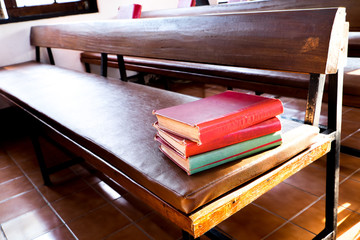 Red books stack on bench.