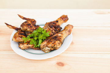 Chicken wings and legs on plate and onion on light wooden background with copyspace. Cuisine background. Eastern food. Street food. Weekend barbeque.