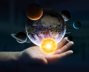Businessman holding solar system in his hand