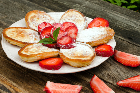 Pancakes with strawberries and powdered sugar