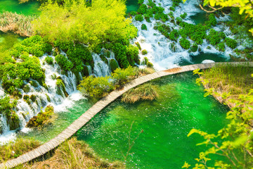 Beautiful landscape, waterfall, clear green water and wooden pathway in the Plitvice Lakes National Park in Croatia. Beautiful world. Panoramic view.