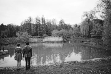 Couple hugging in love at yellow flowers field near lake and pon