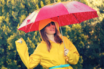 Woman in raincoat with umbrella out in the rain