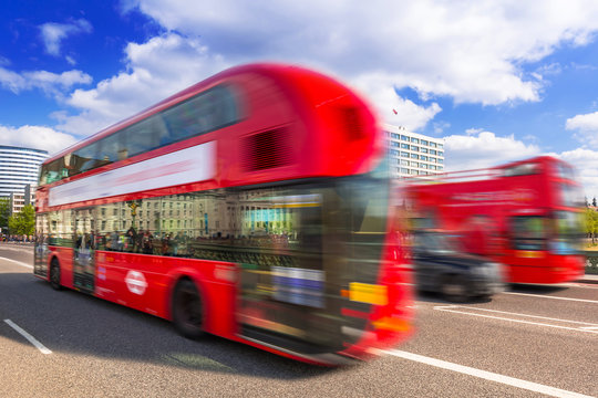 Red double-decker bus in motion on the street of London, UK