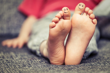 Kids feet with smiley faces drawings © cherryandbees