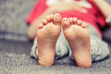 Kids feet with smiley faces drawings - obrazy, fototapety, plakaty