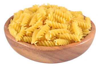 Uncooked italian pasta fusilli in a wooden bowl on a white
