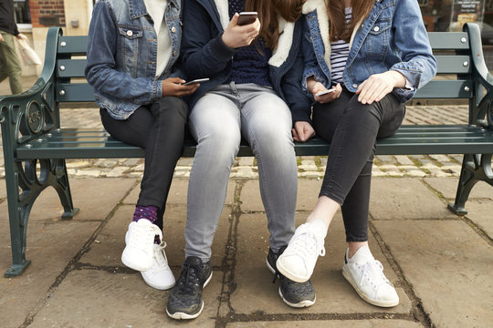 Close Up Of Teenage Girls With Mobile Phones In City Setting