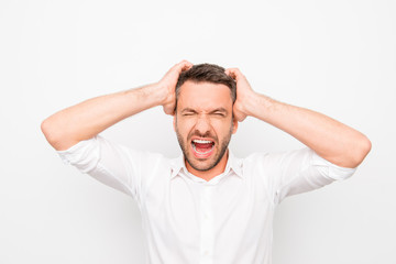 Handsome depressed young man holding his head and screaming