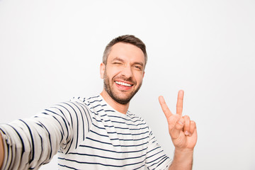 Happy man making selfie and showing two fingers