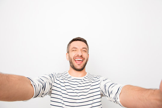 Cheerful happy smiling man making selfie and winking