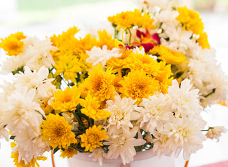 White and yellow colored chrysanthemums in a vase