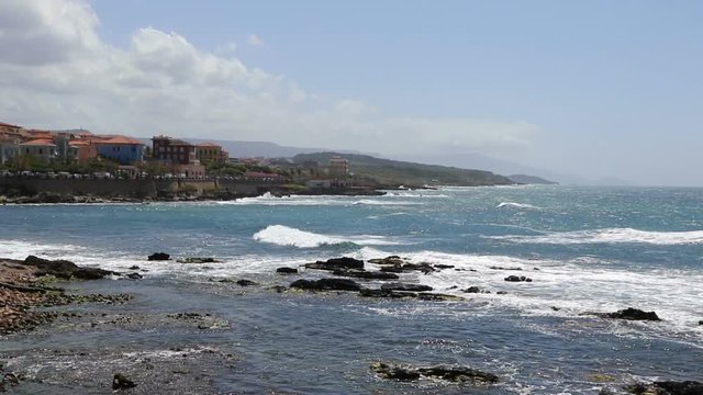 Windy day at rocky seacoast in Alghero city, Sardinia island, Italy