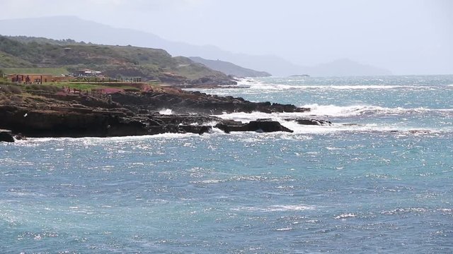 Windy day at rocky seacoast in Alghero city, Sardinia island, Italy