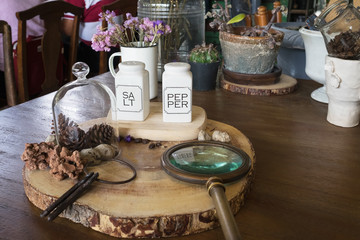 salt and pepper in white bottle as seasoning on wooden table in restaurant with decoration with seasoning