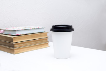 paper cup of coffee is on the table
