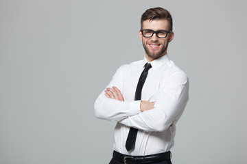 Portrait of handsome young businessman on gray background.