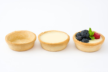 Delicious tartlets with raspberries and blueberries isolated on white background
