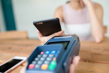 Female pay on mobile phone with pos terminal