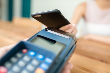 Woman checkout by mobile phone on pos terminal