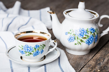 still life with tea cup and tablecloth on wooden table