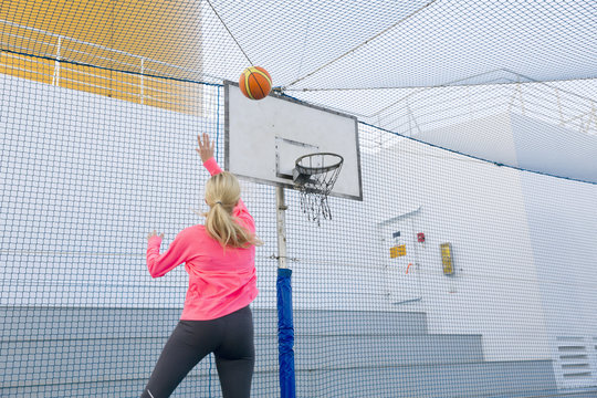 Woman playing basketball on a deck of a cruise ship