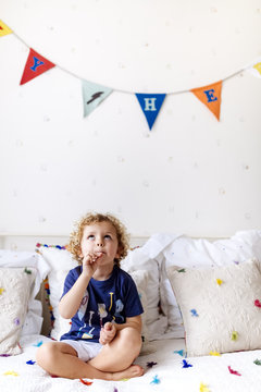 Portrait of little boy with lollipop sitting on the couch