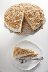 Cheesecake with nuts over white background. Shot from above.