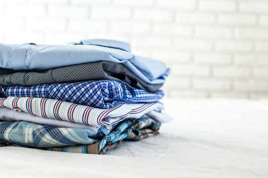 close up of ironed and folded shirts on table at home