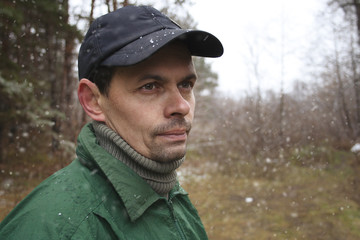 portrait of the man outdoors under the first snow
