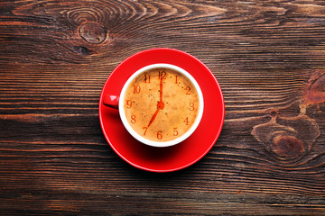 Cup of coffee on wooden table, top view. Time concept