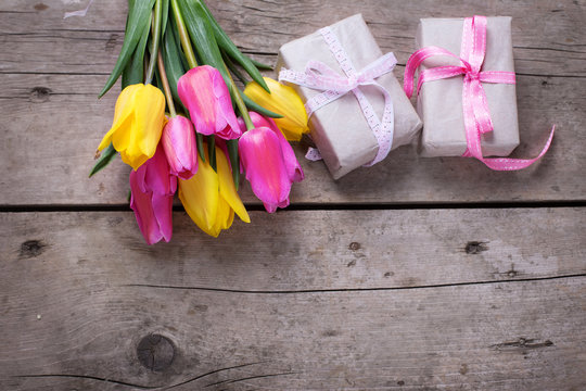 Bunch of bright yellow and pink spring tulips and boxes with pre