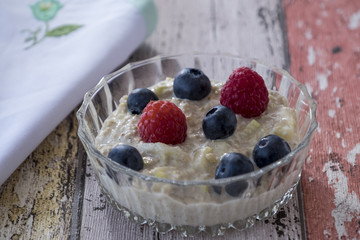 Bircher muesli with fruit on wooden background