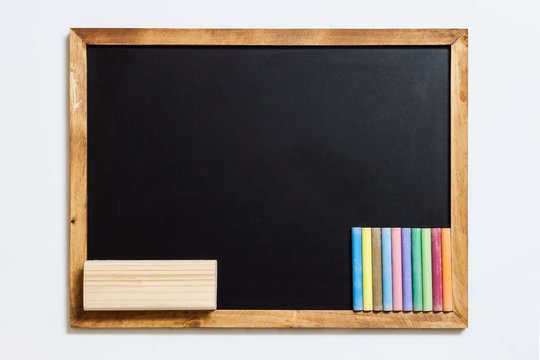 Blank blackboard with colorful chalks and eraser