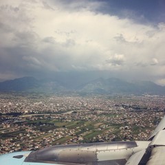 the view from the plane landing in Tirana, Albania during a sunny day with some clouds 