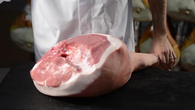 Traditional processing of italian cured ham: salting by hand