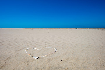 Herz aus Muscheln im Sandstrand