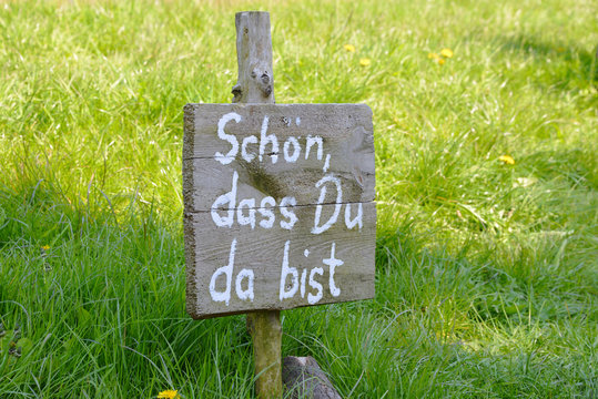 Schild, sch&ouml;n, dass Du da bist, Begr&uuml;&szlig;ung, Willkommen, Herzlichkeit, Gastfreundschaft, Gastgeber, Gras, Holz, rustikal, Empfang, offenes Haus, Gastfreundlichkeit