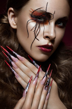 woman in the image of spider with creative art makeup and long nails. Manicure design, beauty face.