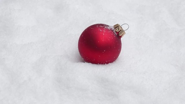 red xmas bauble turning on snow