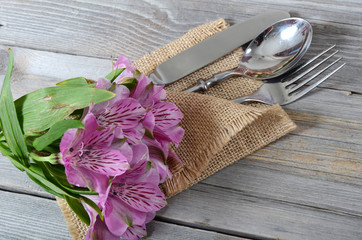 Tableware with flowers on wooden background close up