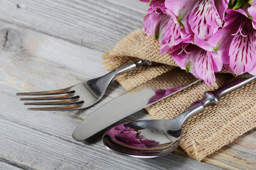 Tableware with flowers on wooden background close up