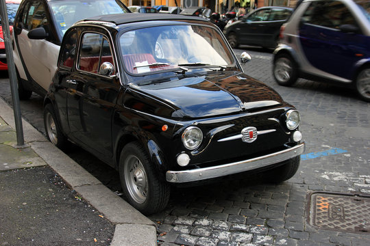 funny black small old little italian car with round headlights a