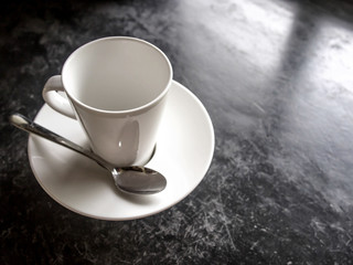 Empty white cup on black floor