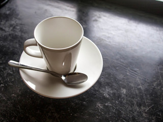 Empty white cup on black floor