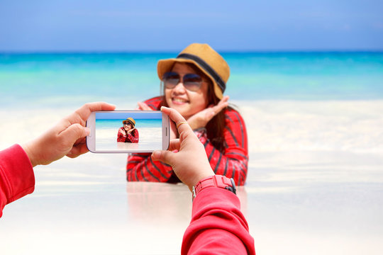 Smartphone photographing Asia woman in Tropical beach, Similan Island, Koh Ta Chai, Andaman Sea, Thailand