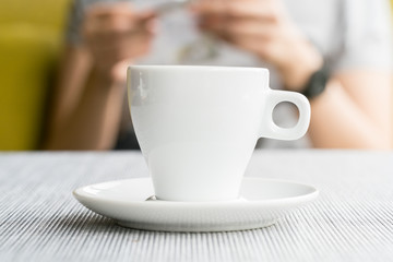 espresso coffee in thick white cup in a cafe, super shallow doc
