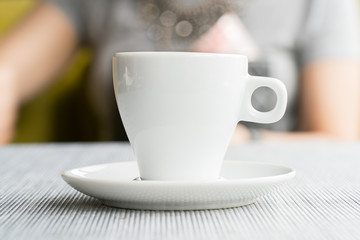 espresso coffee in thick white cup in a cafe, super shallow doc
